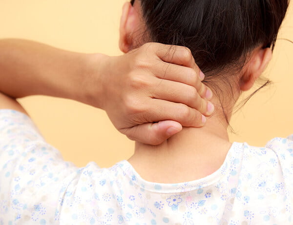 A person grasping the back of their neck, appearing to stretch or relieve discomfort, focusing on neck pain or tension relief - Chiropractor Alpharetta GA